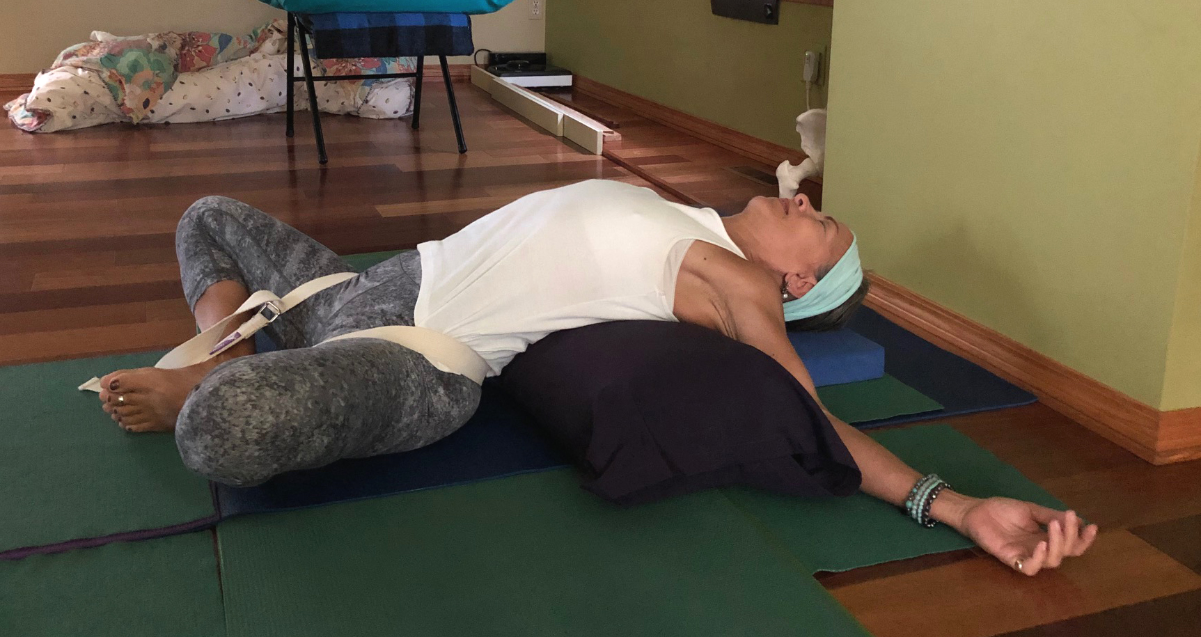 Restorative Yoga With A Bolster. Group Of Three Young Sporty Attractive  Women In Yoga Studio, Lying On Bolster Cushion, Stretching And Relaxing  During Restorative Yoga. Healthy Active Lifestyle. Stock Photo, Picture and